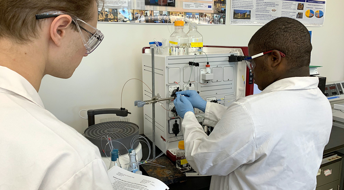 Two technicians in white coats in a science lab